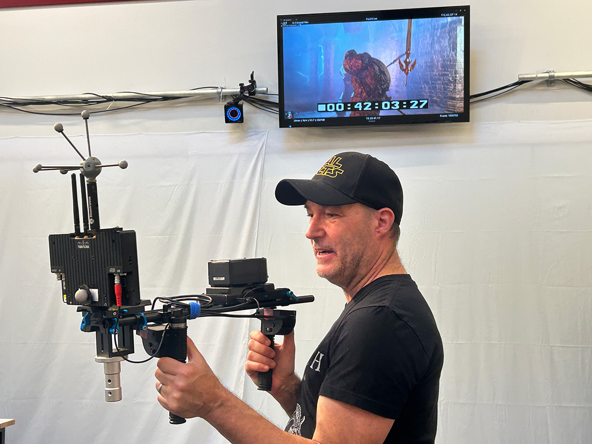 Image Mark Andrews holding the Peel Virtual Camera with a motion capture marker cluster, a screen and attached joystick handles